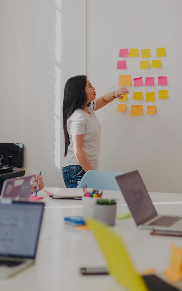 A team planning a project with sticky notes on a wall