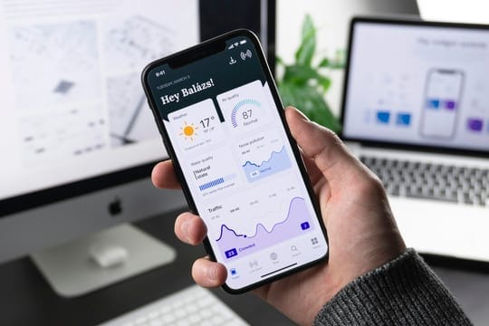 Hand holding a phone with a dashboard app open